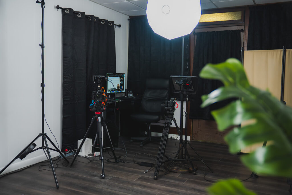 Modern photography studio with professional lighting, backdrops, cameras, and equipment arranged for a shoot.