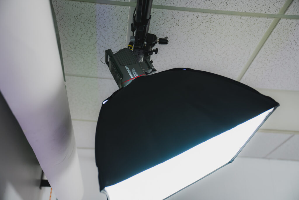 Modern photography studio with professional lighting, backdrops, cameras, and equipment arranged for a shoot.