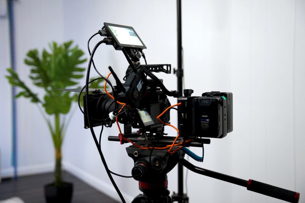 Professional camera setup with tripod, lens, lighting, and accessories arranged for a studio photoshoot or video recording.