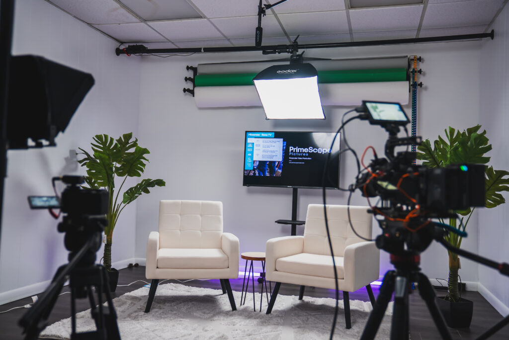 Podcast setup with microphone, headphones, mixing console, computer, and soundproof studio environment.