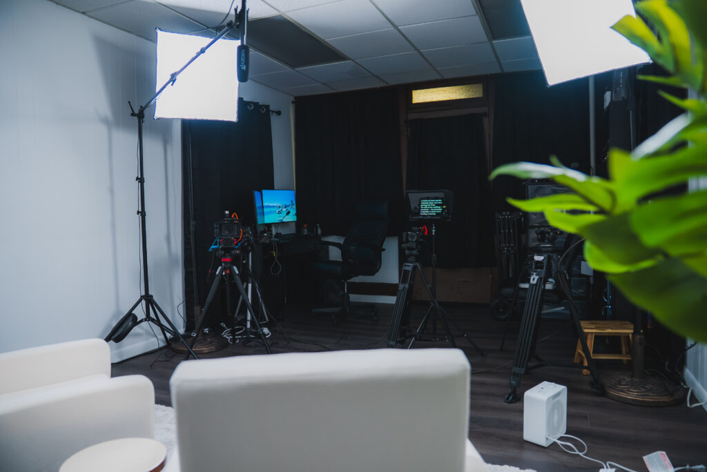 In-studio editing setup with multiple monitors, computer, editing software, and professional lighting for content creation.